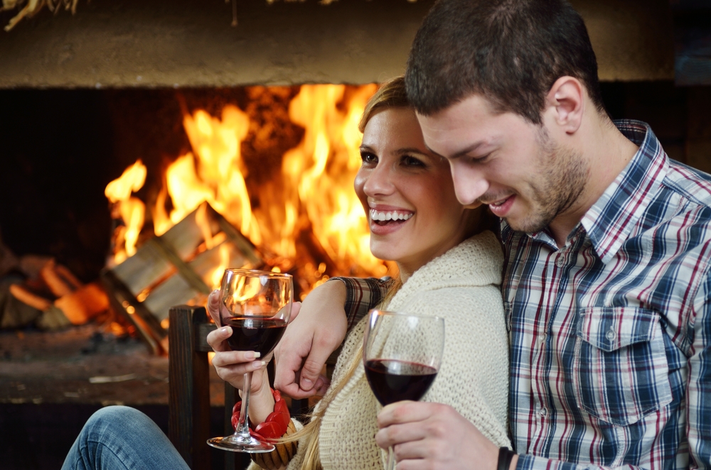 couple sitting in front of fireplace at winter season in home